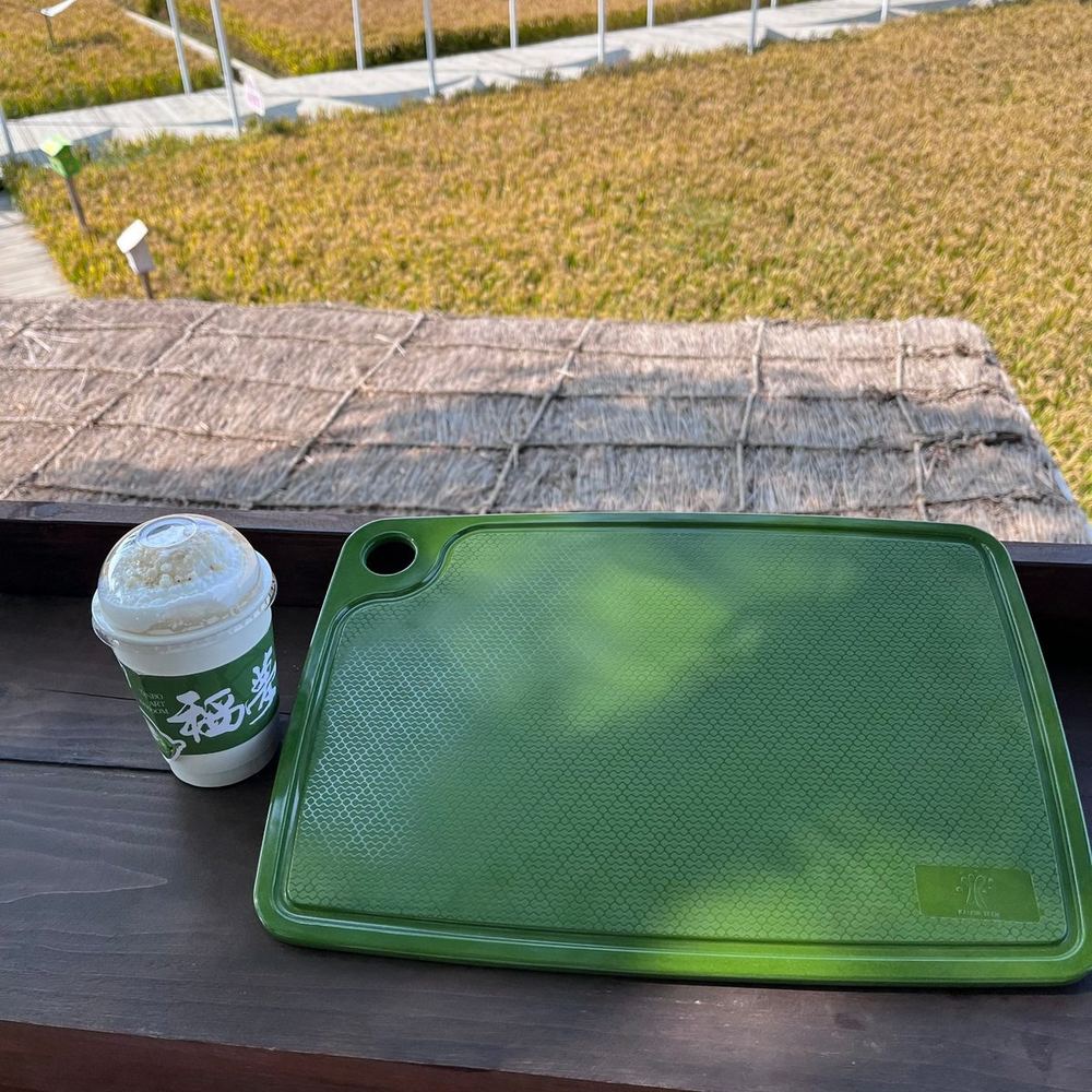 Green rice husk chopping board photographed outdoors — festive colorway for holiday retail ranges