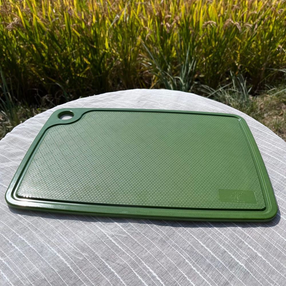 Close-up of a green rice husk chopping board with honeycomb texture surface — molded plant fiber tableware detail